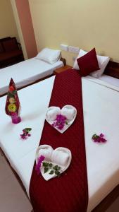 two beds with towels and flowers on them at Hotel Shubham in Karīmnagar +12 photos