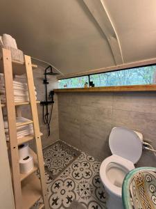 a bathroom with a toilet in a small room at צימרים בצפון - קאמפ דיוויד in Sheʼar Yashuv