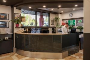 a man standing at a counter in a restaurant at Hotel Martini in Verona