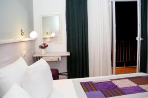 a hotel room with a bed and a mirror at Hotel Delisi in Tbilisi City