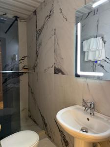 a bathroom with a sink and a toilet and a mirror at Rritja e Koranit in Pogradec +72 photos