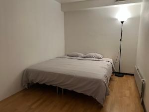 a small bedroom with a bed and a lamp at 2 bedrooms 1 bathroom kitchen apartment in Stockholm
