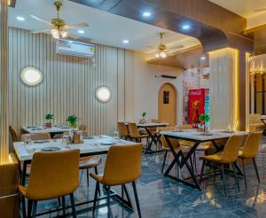 a row of tables and chairs in a restaurant at Majestic Royal by Travel Pleasure Hotels in Akalkot