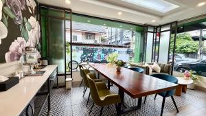 a dining room with a long table and chairs at VIVA LA VIDA HOTEL in Bangkok