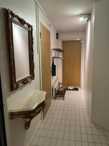 a bathroom with a mirror and a white tile floor at 2 bedrooms 1 bathroom kitchen apartment in Stockholm