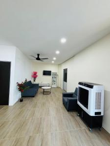 a living room with a couch and a tv at May Ong Guest House in Taiping