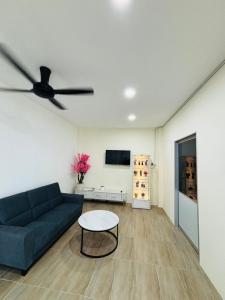 a living room with a blue couch and a ceiling fan at May Ong Guest House in Taiping