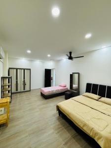a bedroom with two beds and a ceiling fan at May Ong Guest House in Taiping