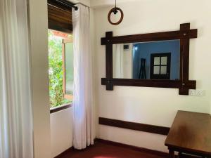 a room with a mirror and a table and a window at Galeena Guest in Badulla