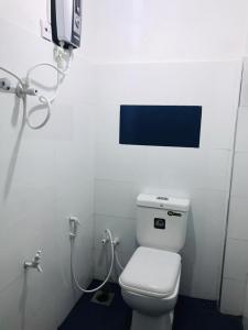 a bathroom with a toilet and a tv on the wall at Galeena Guest in Badulla