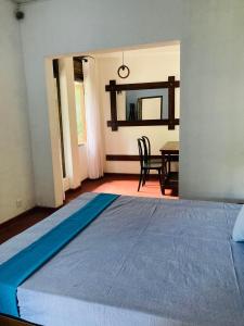 a bedroom with a bed and a table and a mirror at Galeena Guest in Badulla +1 photo