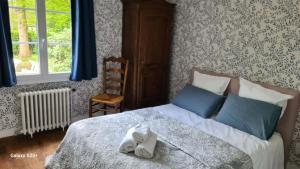a bedroom with a bed with towels on it at LA TANIÈRE in Gueures