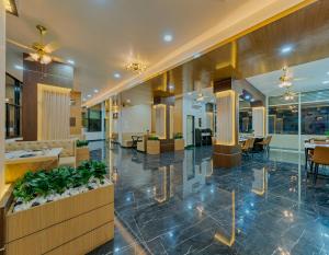 a lobby of a hotel with tables and chairs at Majestic Royal by Travel Pleasure Hotels in Akalkot