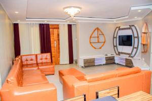a living room with orange furniture and a mirror at Relaxing Lodge in Kigali