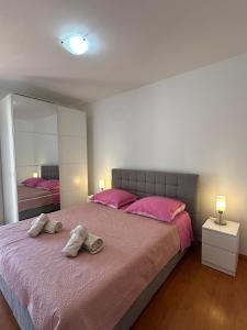 a bedroom with a large bed with pink sheets and pink pillows at Apartment Nina with private pool in Nova Vas