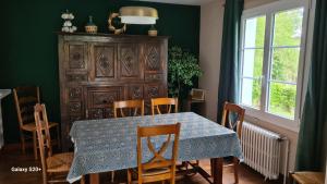 a dining room with a table and chairs and a cabinet at LA TANIÈRE in Gueures +41 photos