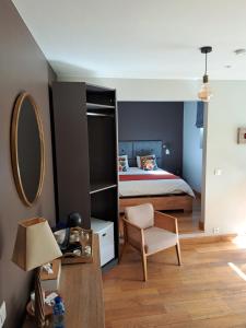 a bedroom with a bed and a mirror at La Suite Des Pervenches in Spa