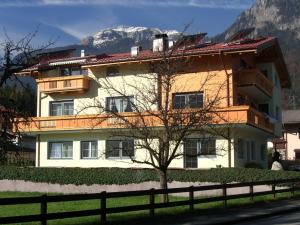 ein Gebäude mit einem Baum davor in der Unterkunft Apartment Neuhauser in Kramsach