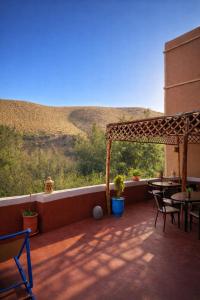 a patio with tables and chairs and a view of a hill at DAR DANI café restaurant in Boumalne Dades