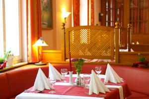 a restaurant with two tables with red and white napkins at Hotel Goldener Fasan in Oranienbaum-Wörlitz