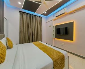 a bedroom with a bed and a tv on the wall at Majestic Royal by Travel Pleasure Hotels in Akalkot