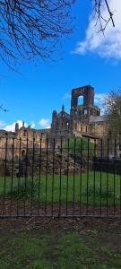 an old castle is seen behind a fence at Ground Floor Apartment, Garden and free parking - 10 The Rise in Kirkstall