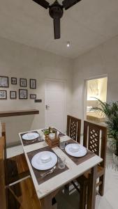 a dining room with a table with chairs and a ceiling fan at Prime Suites in Varkala +2 photos