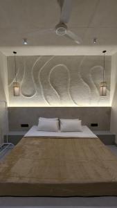 a bedroom with a large bed with two white pillows at Prime Suites in Varkala