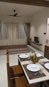 a dining room with a table with plates and chairs at Prime Suites in Varkala