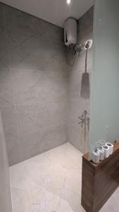 a bathroom with a shower with a tiled floor at Prime Suites in Varkala