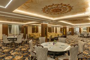 a banquet room with tables and chairs and a chandelier at Perfectstayz Premium Aurevva, Rajpur road in Rājpur +125 photos