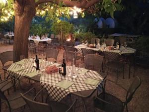 a group of tables and chairs with wine bottles at Campastrello Sport Hotel Residence in Castagneto Carducci