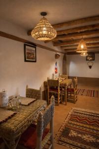 a dining room with tables and chairs and chandeliers at DAR DANI café restaurant in Boumalne Dades