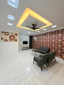 a living room with a ceiling fan and a table and chairs at Kings Park Homestay in Ipoh