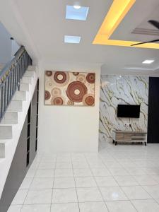 a room with a television and a wall with paintings at Kings Park Homestay in Ipoh