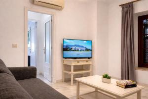 a living room with a couch and a television at Apartamentos Larga 70 in El Puerto de Santa María