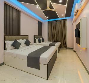 two beds in a hotel room with a tv at Majestic Royal by Travel Pleasure Hotels in Akalkot +30 photos