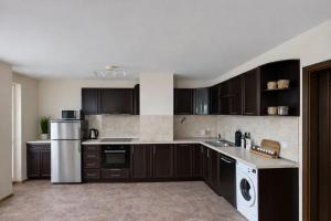 a kitchen with dark brown cabinets and appliances at River Park Oasis apartment in Sandanski +4 photos