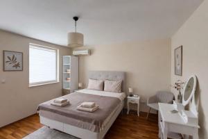 a bedroom with a bed with two towels on it at River Park Oasis apartment in Sandanski