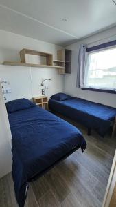 a room with two beds and a window at Mobilhome Normandie in Litteau