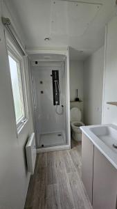 a white bathroom with a toilet and a sink at Mobilhome Normandie in Litteau +10 photos