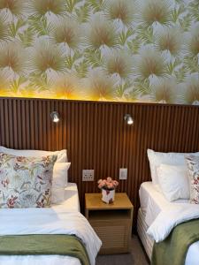 a hotel room with two beds and a wall with a wallpaper at Townside Estate Room number 10 in Ladysmith +3 photos