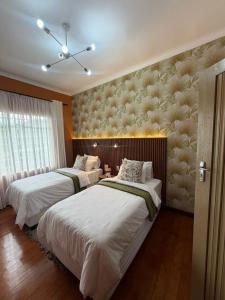 a bedroom with two beds and a wall mural at Townside Estate Room number 10 in Ladysmith