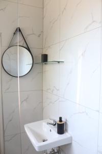 a white bathroom with a sink and a lamp at Townside Estate Room number 10 in Ladysmith