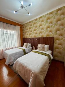 a bedroom with two beds and a large window at Townside Estate Room number 10 in Ladysmith