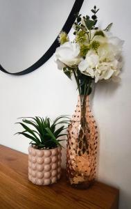two vases sitting on a table with flowers in them at Dimora Tarantina in Taranto