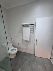 a bathroom with a toilet and a glass door at Savusavu Terraces - Unit 3 in Savusavu +6 photos