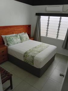 a bedroom with a large bed with a window at Savusavu Terraces - Unit 3 in Savusavu