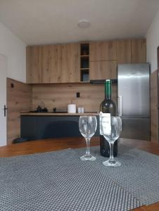 a bottle of wine and two wine glasses on a table at MiYo STAY in Žitkovac