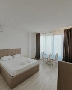 a bedroom with a bed and a table with chairs at Hotel Restaurant Univers Shiroke in Shirokë